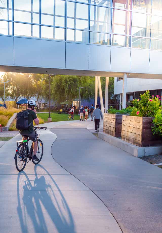 A student cycling across campus