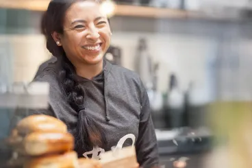 woman smiles from behind counter