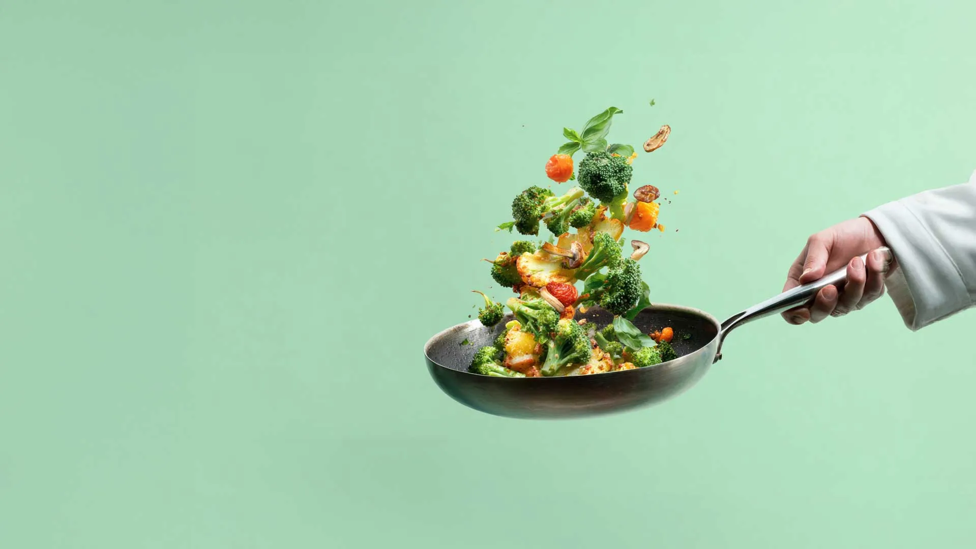 Vegetables being tossed in saute pan